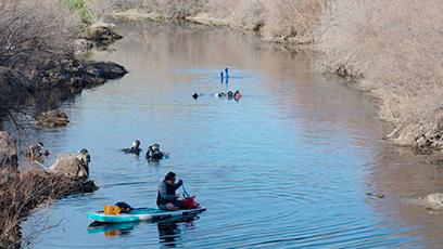 volunteers in kayaks engaged in river cleanup