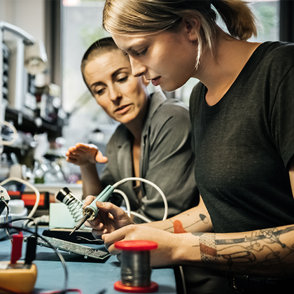 student apprentice working with mentor with mechanical device