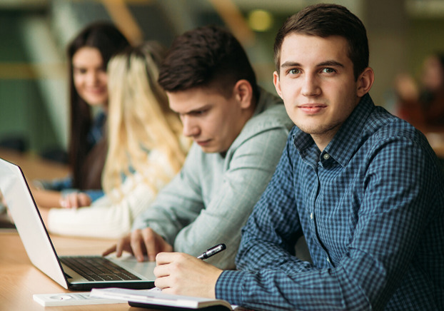 student sitting in classroom with laptop