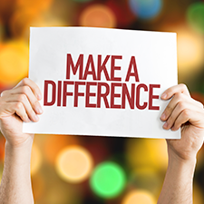 hands holding up sign that reads make a difference