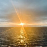 Sunset with a cloudy sky over water landscape photo.