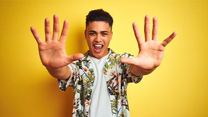 student wearing tshirt and aloha shirt holding up hands with 10 fingers