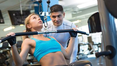 student working out while trainer observes