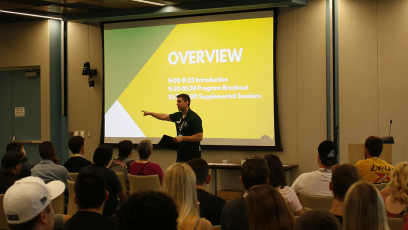 A lecturer in an auditorium introducing new students to SCC.