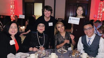 Stephanie Fujii at a ceremony posing with a group of other professionals.