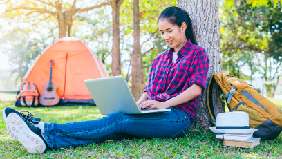 female with laptop in campground