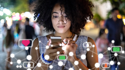 female student gazing intently at mobile device while coding