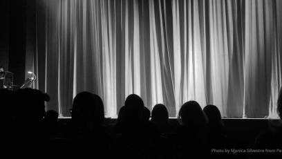 stage with curtains drawn and audience silhouette