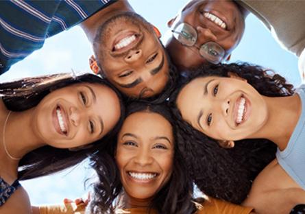 students smiling downwards at an upwards facing camera