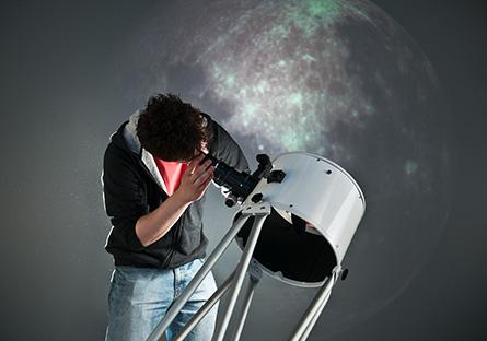 person looking through a telescope at starry sky