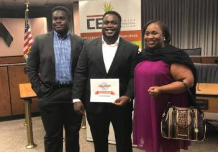 A photo of Wilson Okwuobu as he poses with his award beside his family.