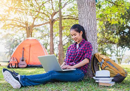 female with laptop in campground