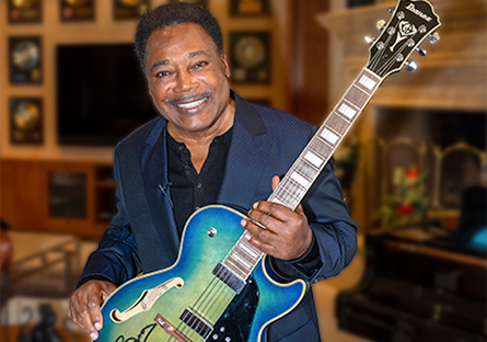 George Benson holding  guitar