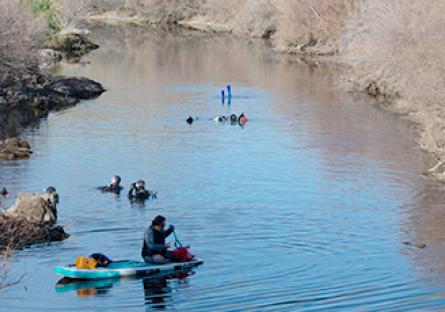 volunteers in kayaks engaged in river cleanup