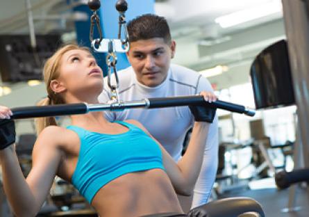 student working out while trainer observes