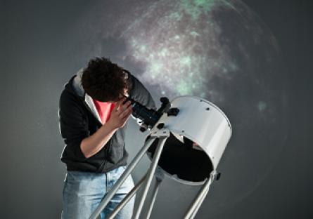 person looking through a telescope at space