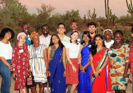 A diverse group of International Exchange students posing for a photo in the desert.