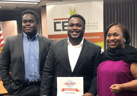 A photo of Wilson Okwuobu as he poses with his award beside his family.