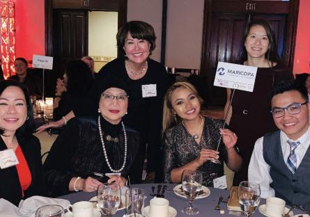 Stephanie Fujii at a ceremony posing with a group of other professionals.