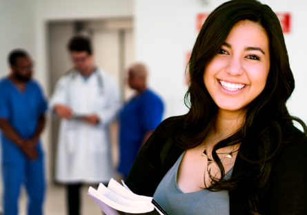 student carrying books with backdrop of medical instructors