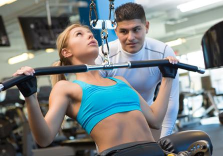 trainer watching student lift weights