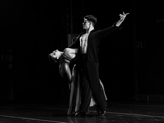 two dancers on stage wearing formal wear