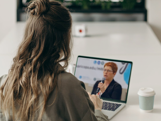 female watching presentation on laptop