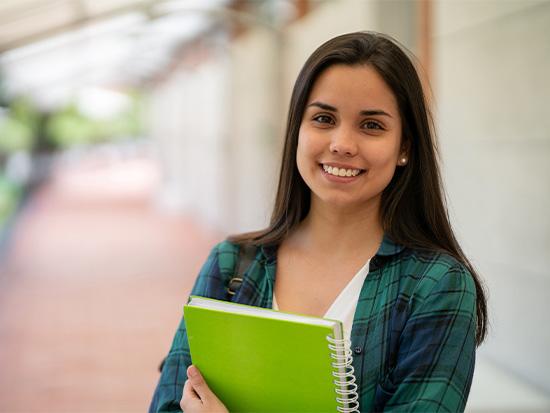 smiling student holding a notebook