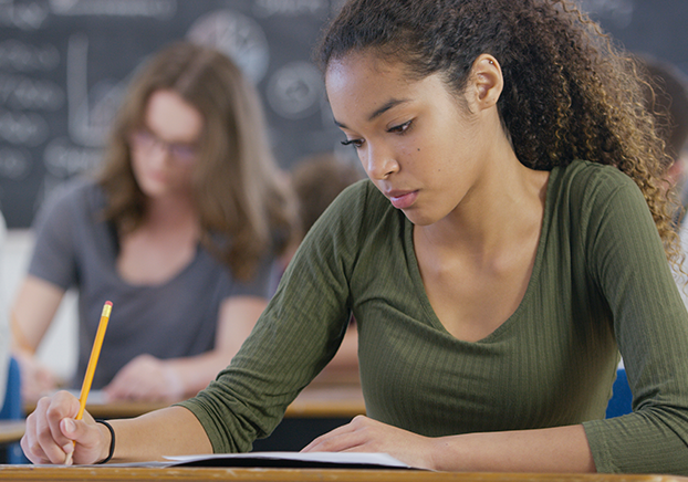student looking down and writing in class