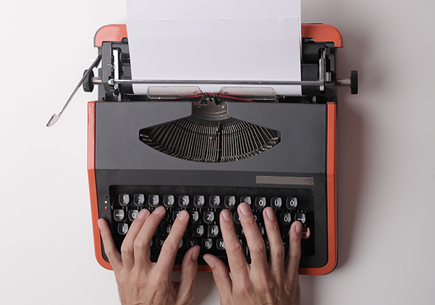 hands typing on a typewriter