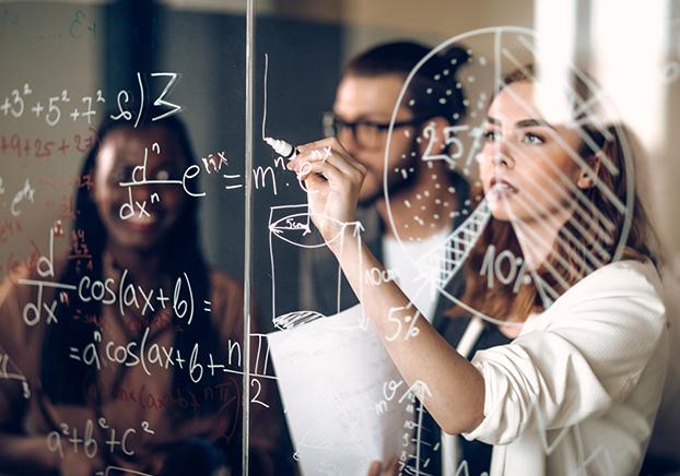 student solving math problem on chalkboard