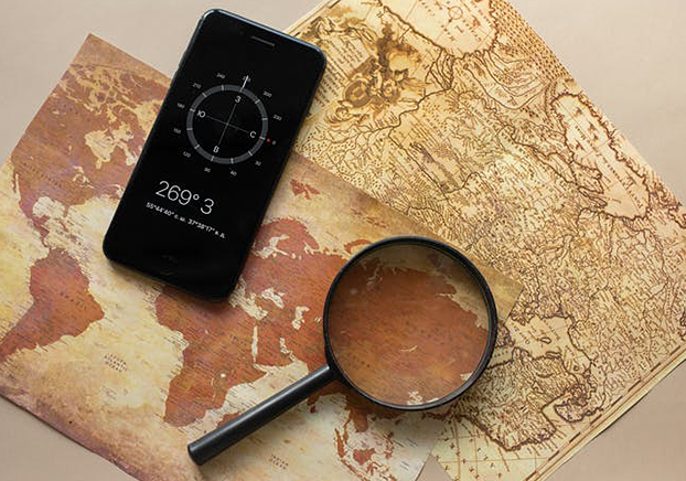 magnifying glass and phone on a map on a table