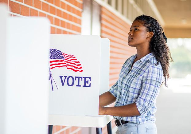 student at an outdoor voting booth