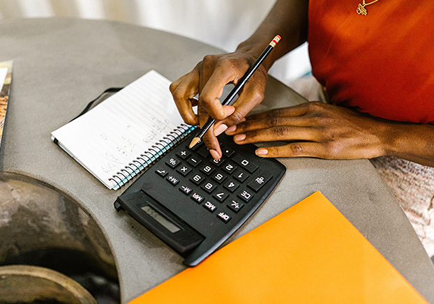 student working at a table using a calculator