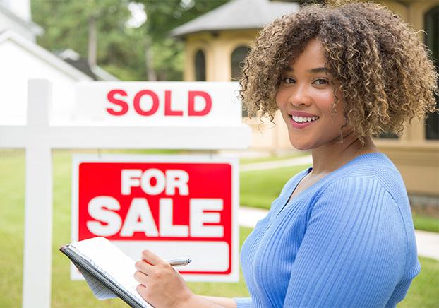 realtor pointing to a for sale and sold sign