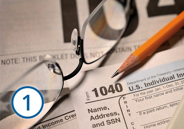 compilation of federal tax return paperwork, eyeglasses and pencil