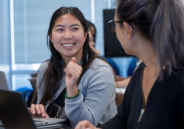 STEP student smiling at another student